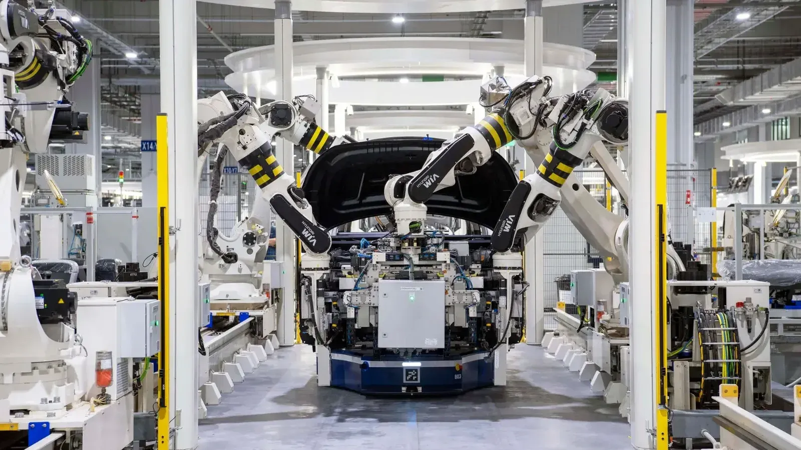 High-tech robots assembling a car in a modern factory setting, showcasing automation.