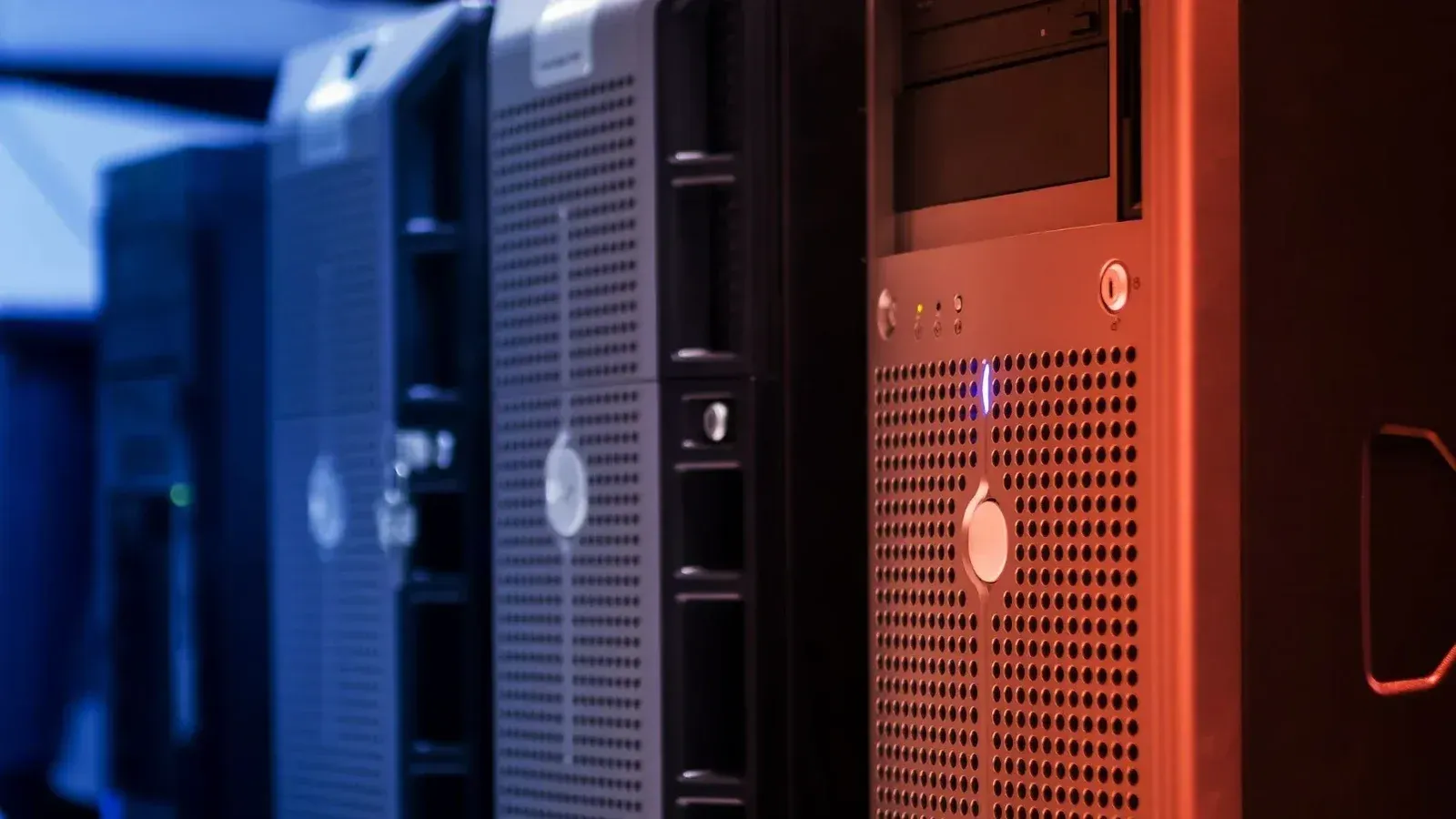 Close-up of tower servers in a data center with blue and red lighting.
