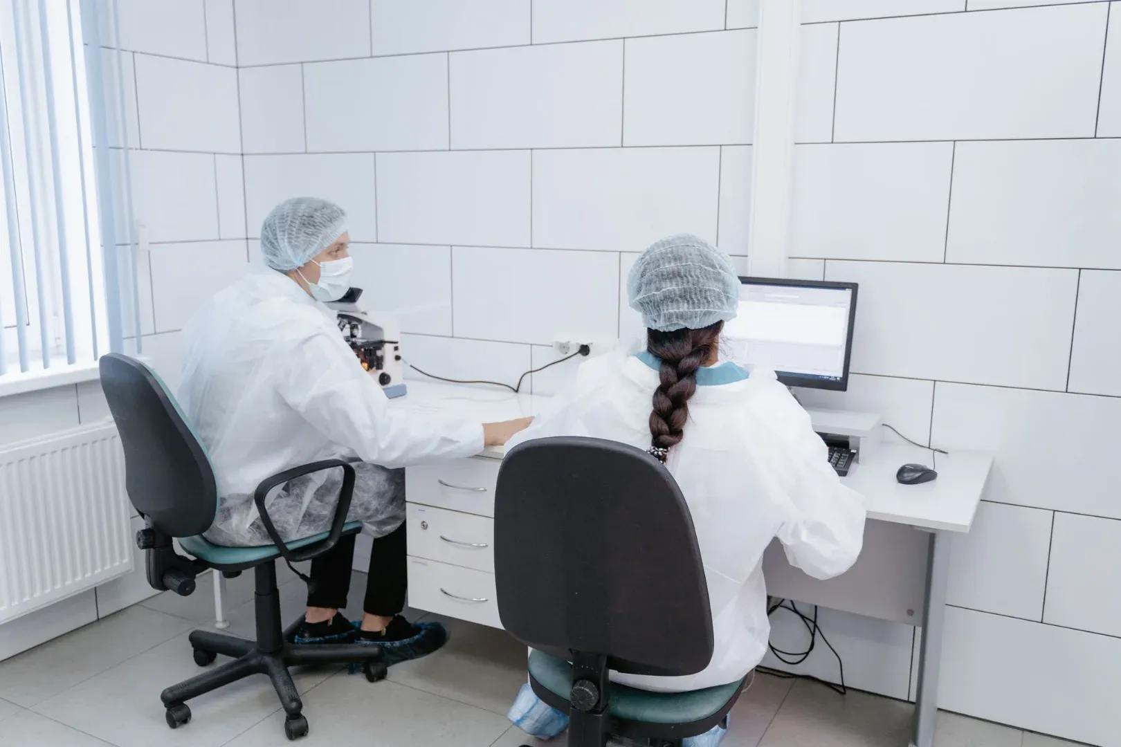 Two scientists working together in a sterile lab environment.
