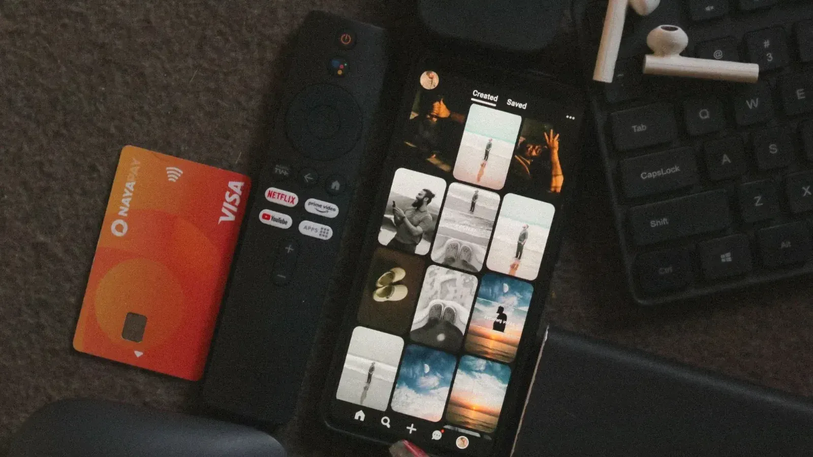 Flat lay of a smartphone, remote control, credit card, and gadgets for a tech-savvy lifestyle.