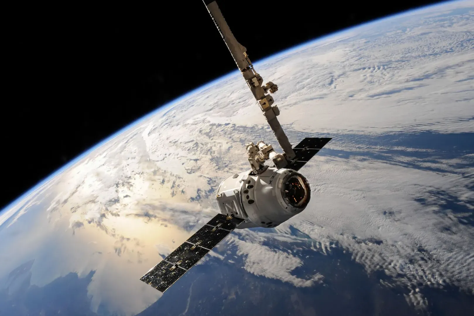 Un satélite se desliza sobre la tierra que muestra formaciones de nubes dramáticas y la vasta extensión del espacio.
