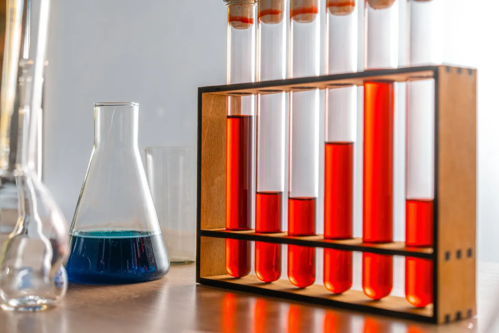 Vibrant laboratory scene featuring test tubes with colored liquids in a wooden rack.