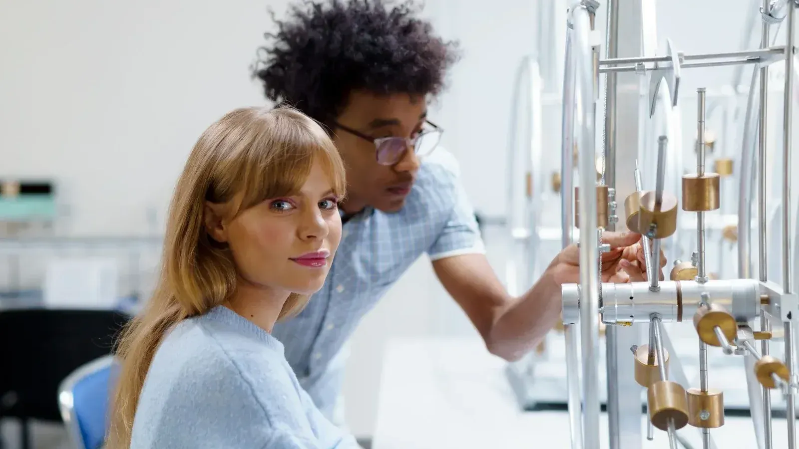 University students exploring physics concepts in a laboratory setting with experimental equipment.