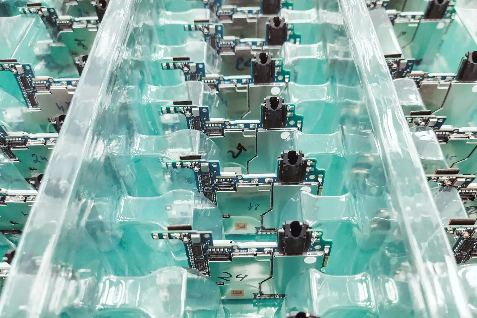 Vista detallada de placas de circuitos electrónicos organizados en un entorno de producción.