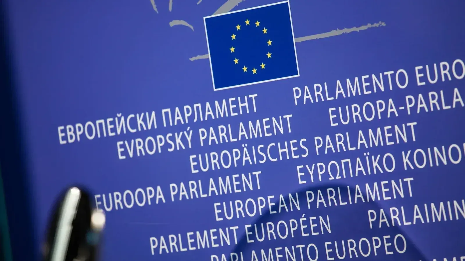 Close-up view of the European Union flag with multilingual text showing European Parliament.
