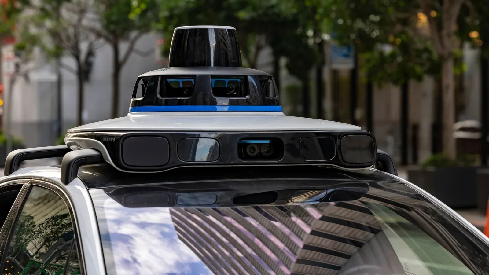 Detailed view of sensors atop an autonomous car, showcasing advanced technology in an urban setting.