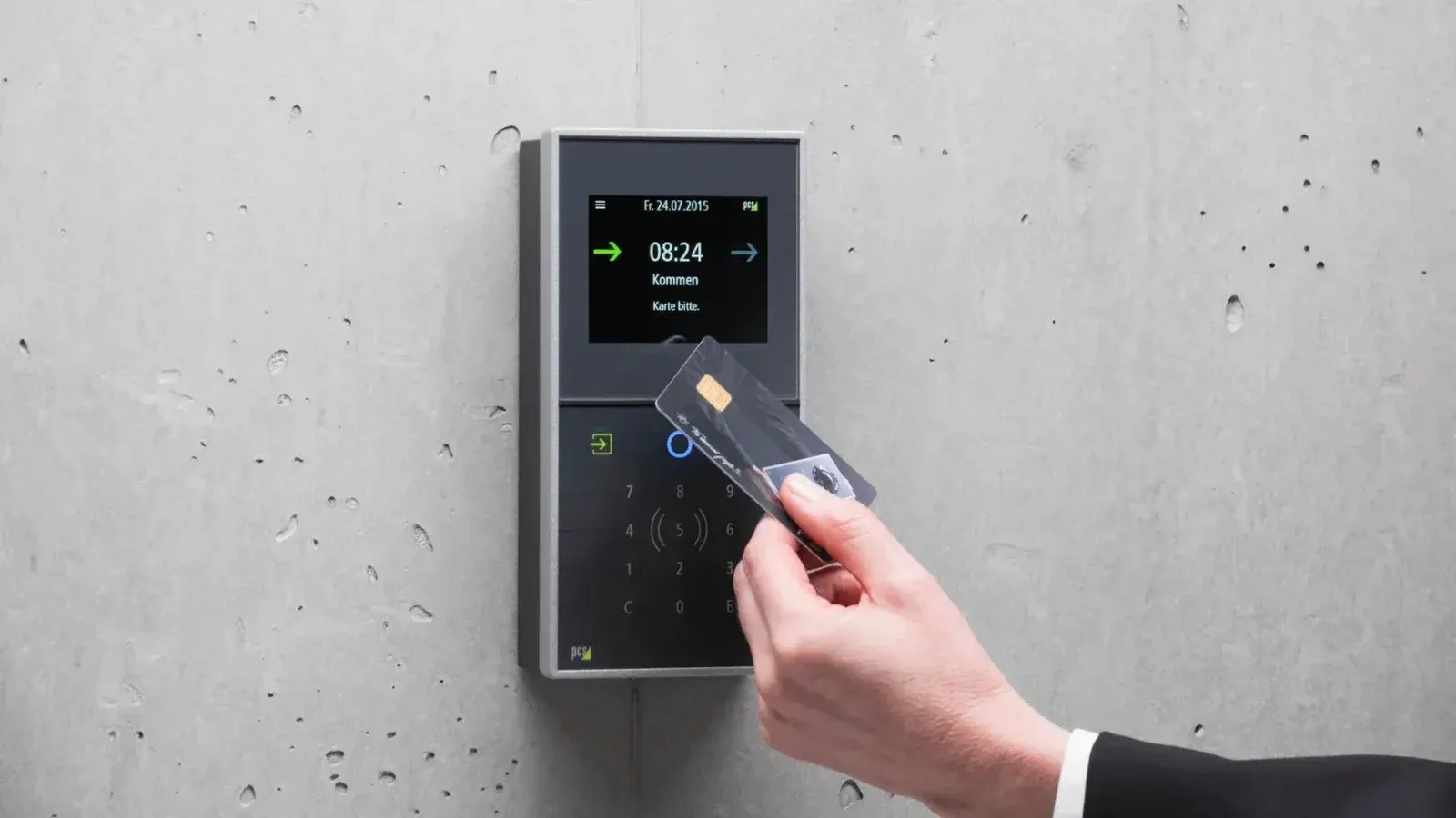 A businessman uses a secure card reader access system against a concrete wall.