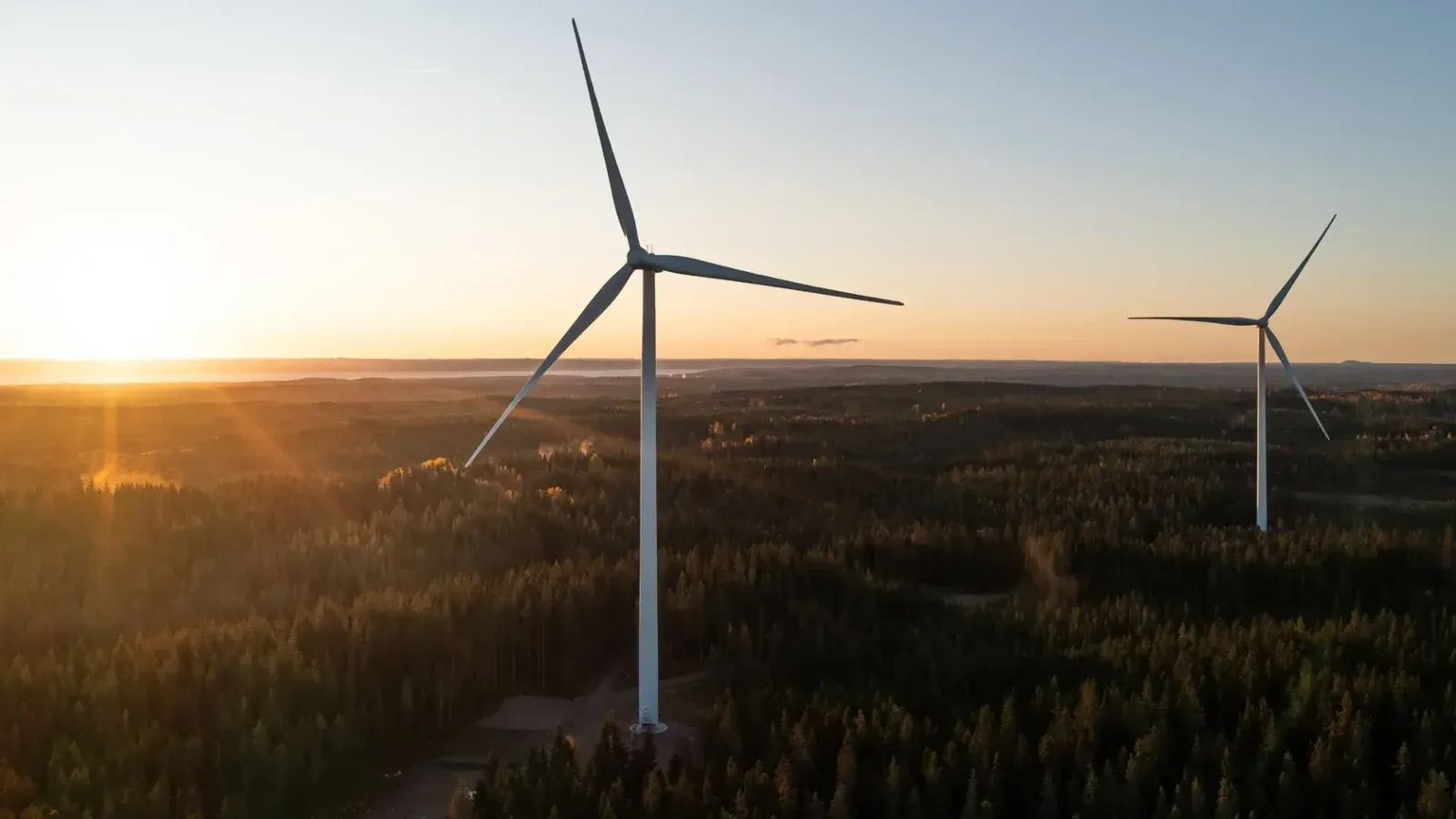 Turbinas de viento en un entorno rural con la puesta de sol detrás