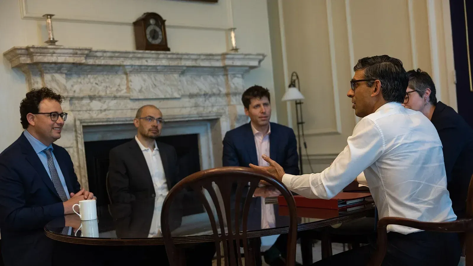 El primer ministro británico Rishi Sunak conversa en Downing Street con Dario Amodei, Demis Hassabis y Sam Altman, sentados alrededor de una mesa frente a una chimenea