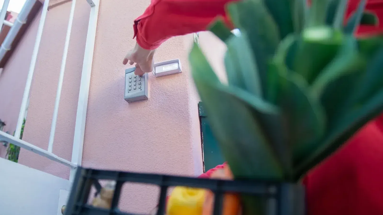 Primer plano de una persona que usa un teclado de seguridad en una puerta, resaltando el control de acceso a casa.