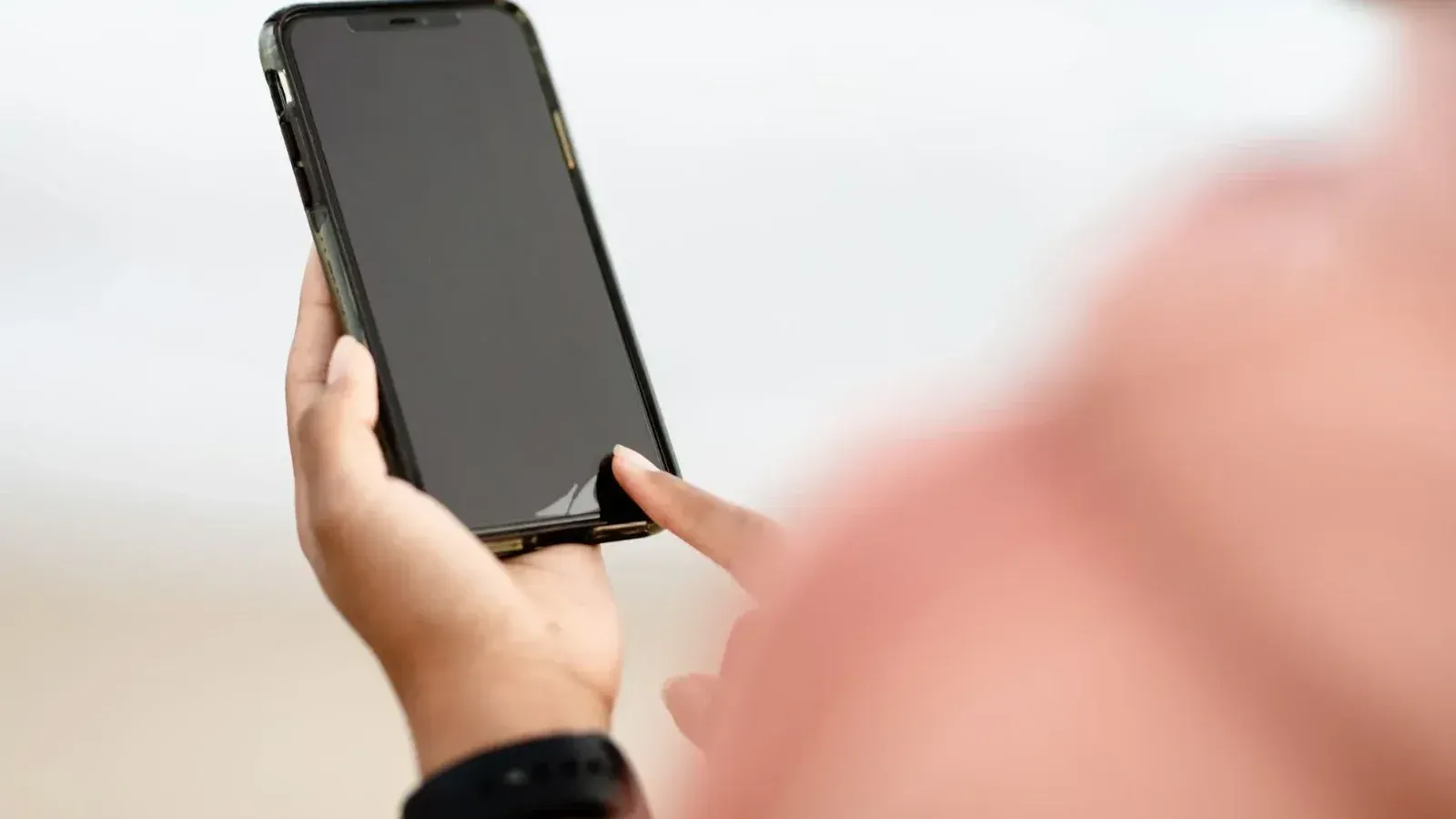 Una mano interactuando con una pantalla táctil de smartphone al aire libre. Concepto de tecnología moderna.