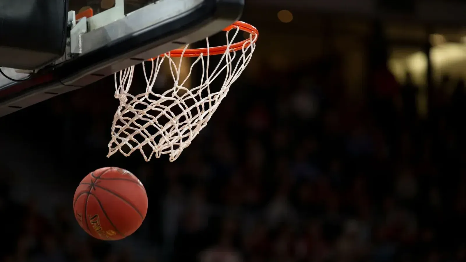 A basketball going through the hoop during a fast-paced game, capturing the excitement of the sport.