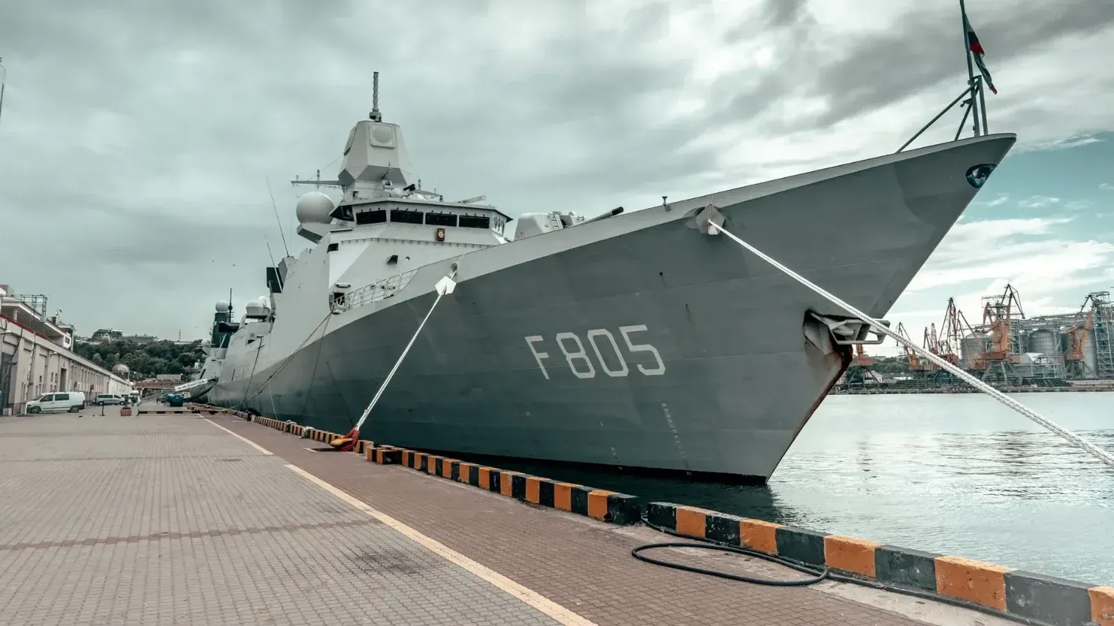 Un gran barco naval atracado en el puerto de Odessa bajo un cielo nublado, mostrando fuerza marítima.