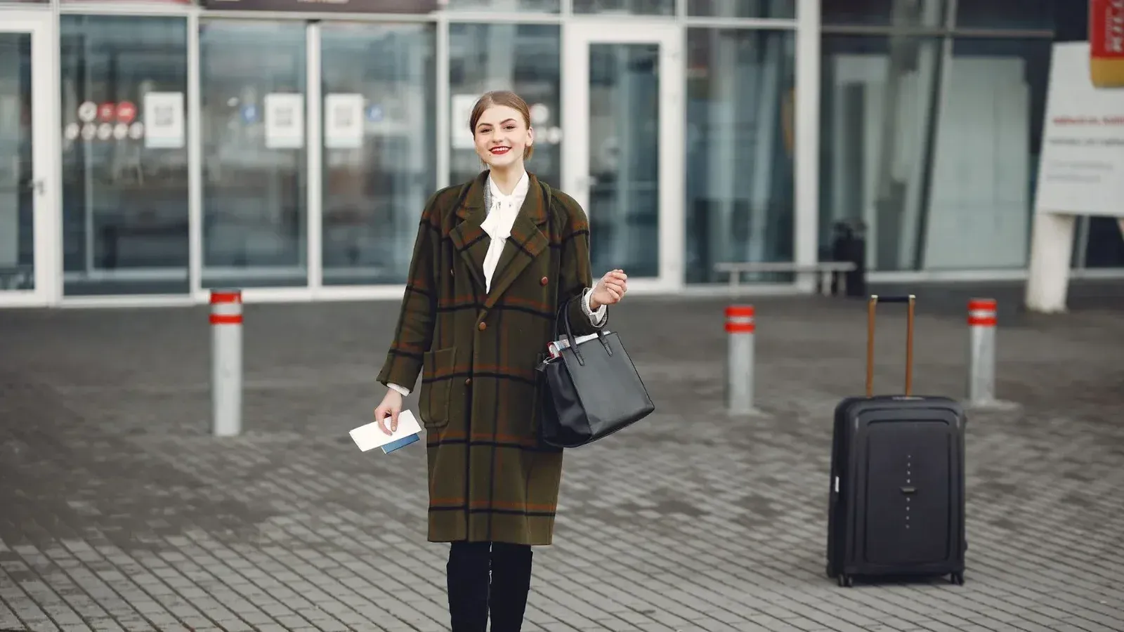 Mujer de moda con equipaje llega al aeropuerto listo para viajar.