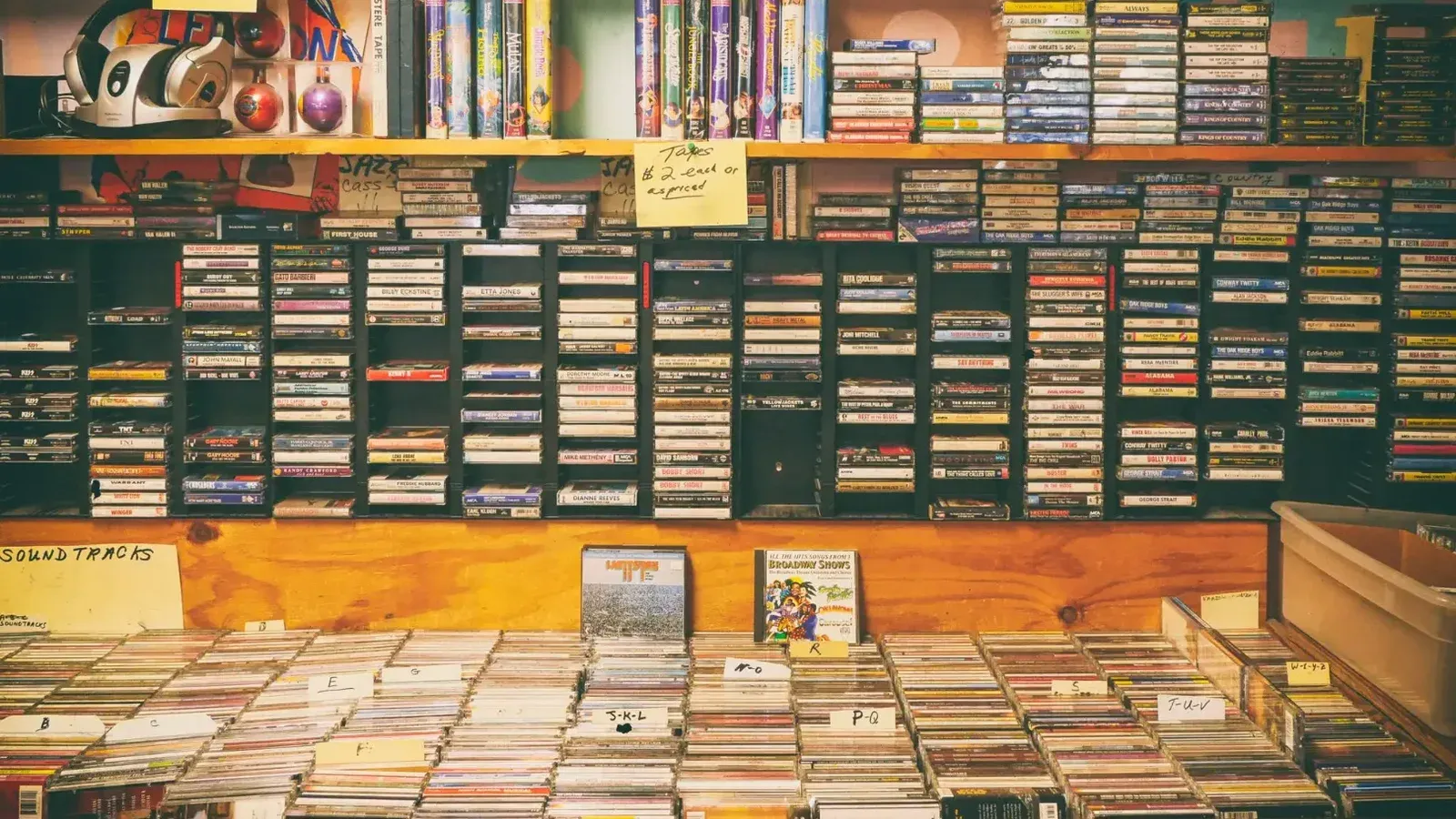 Una exhibición nostálgica de cintas de casete y CD en una tienda de discos vintage.