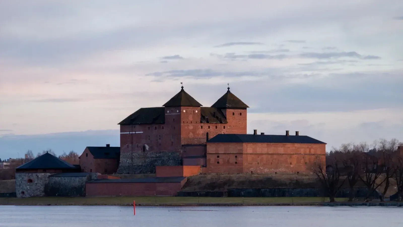 Hermosa vista del castillo medieval de Häme bajo un cielo crepuscular en Hämeenlinna, Finlandia.