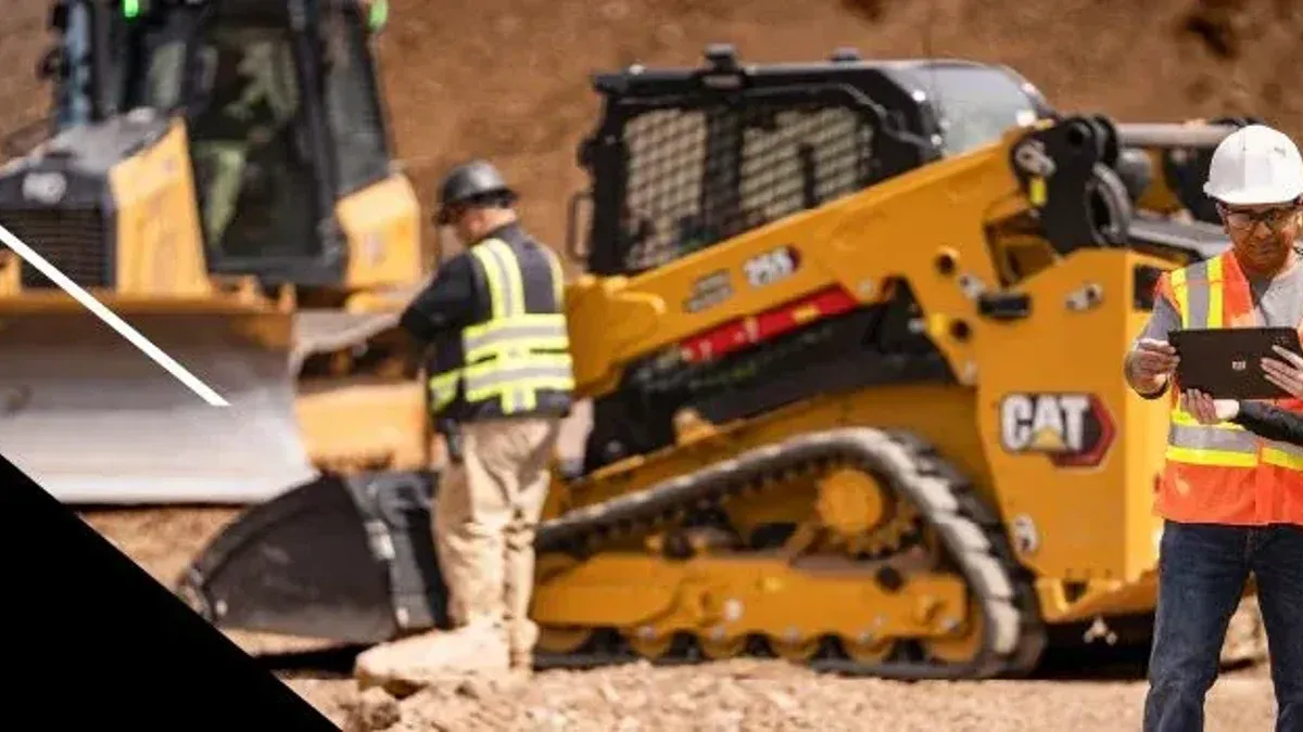 Cat dealer and customer consulting on a worksite while Cat machines are being serviced