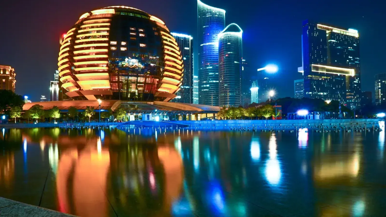 Impresionante reflejo del horizonte iluminado de Hangzhou con arquitectura moderna durante la noche.