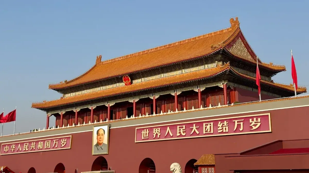 Historic Tiananmen Gate under blue skies in Beijing, China, symbolic and tourist landmark.