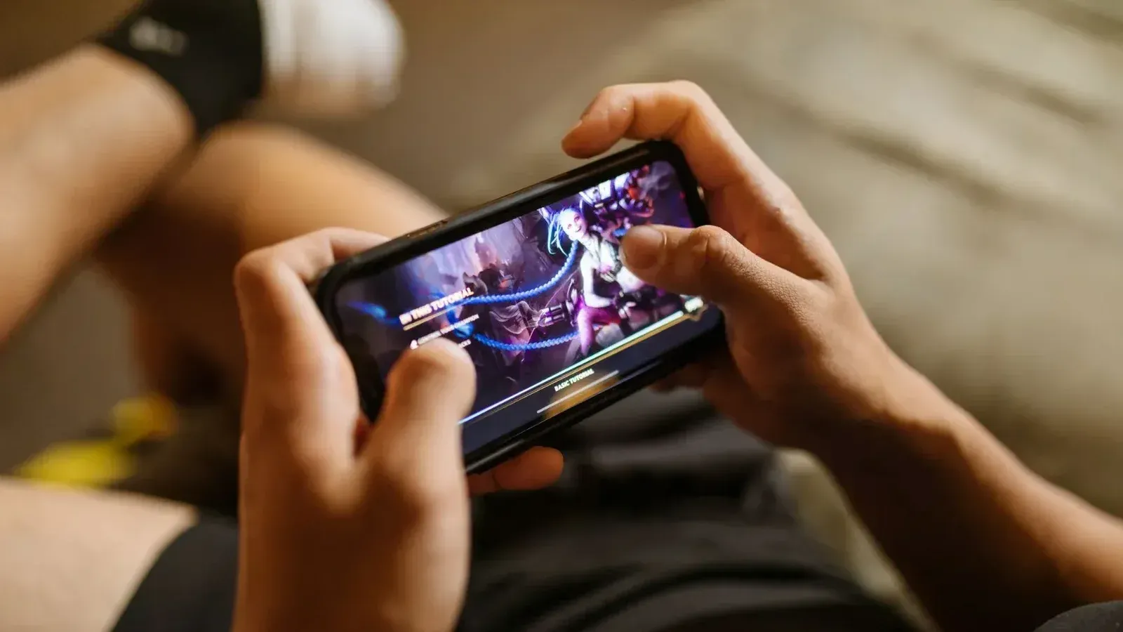 Una persona que juega un videojuego móvil en un teléfono inteligente, centrándose en el estilo de vida de los juegos y la tecnología.