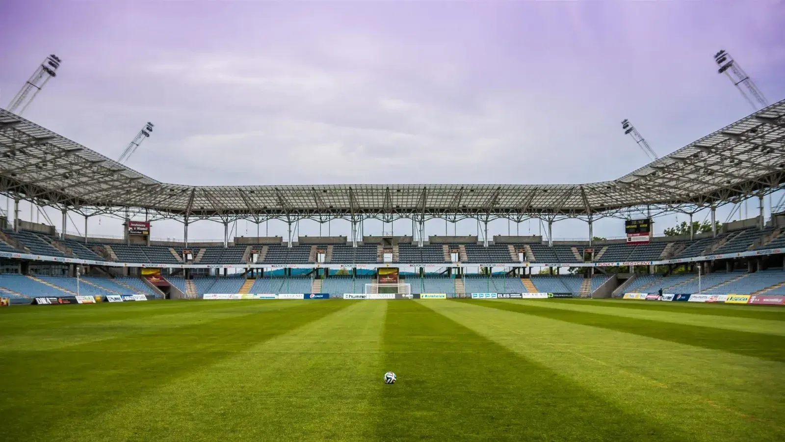 Explore un estadio de fútbol con cielos despejados y hierba prístina, perfecto para cualquier evento deportivo.