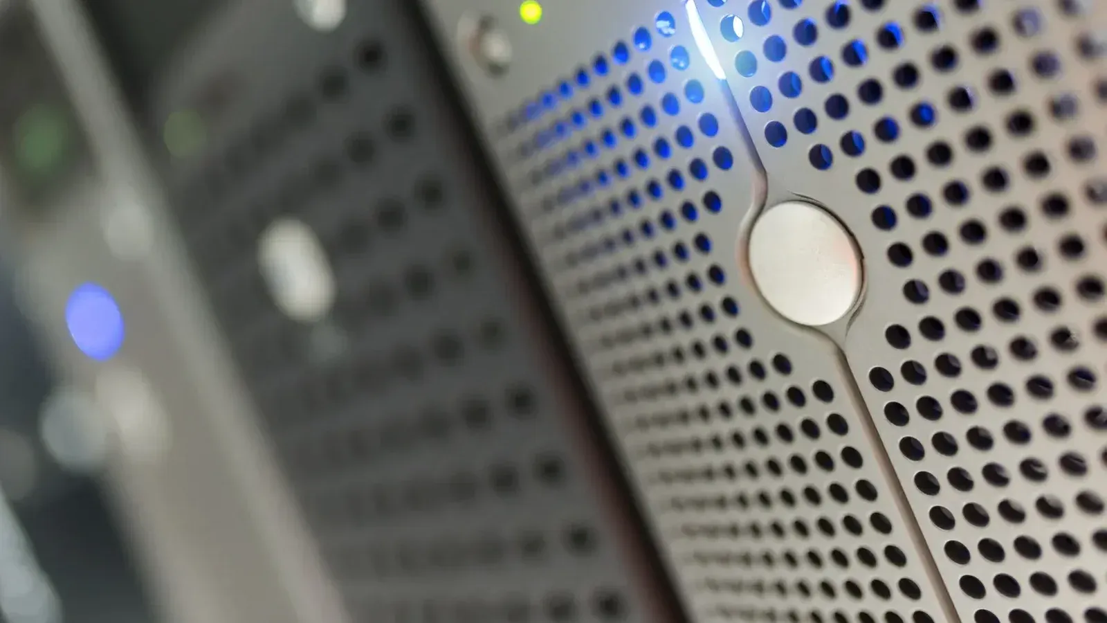 Focused detail of a modern server rack with blue LED indicators in a data center.