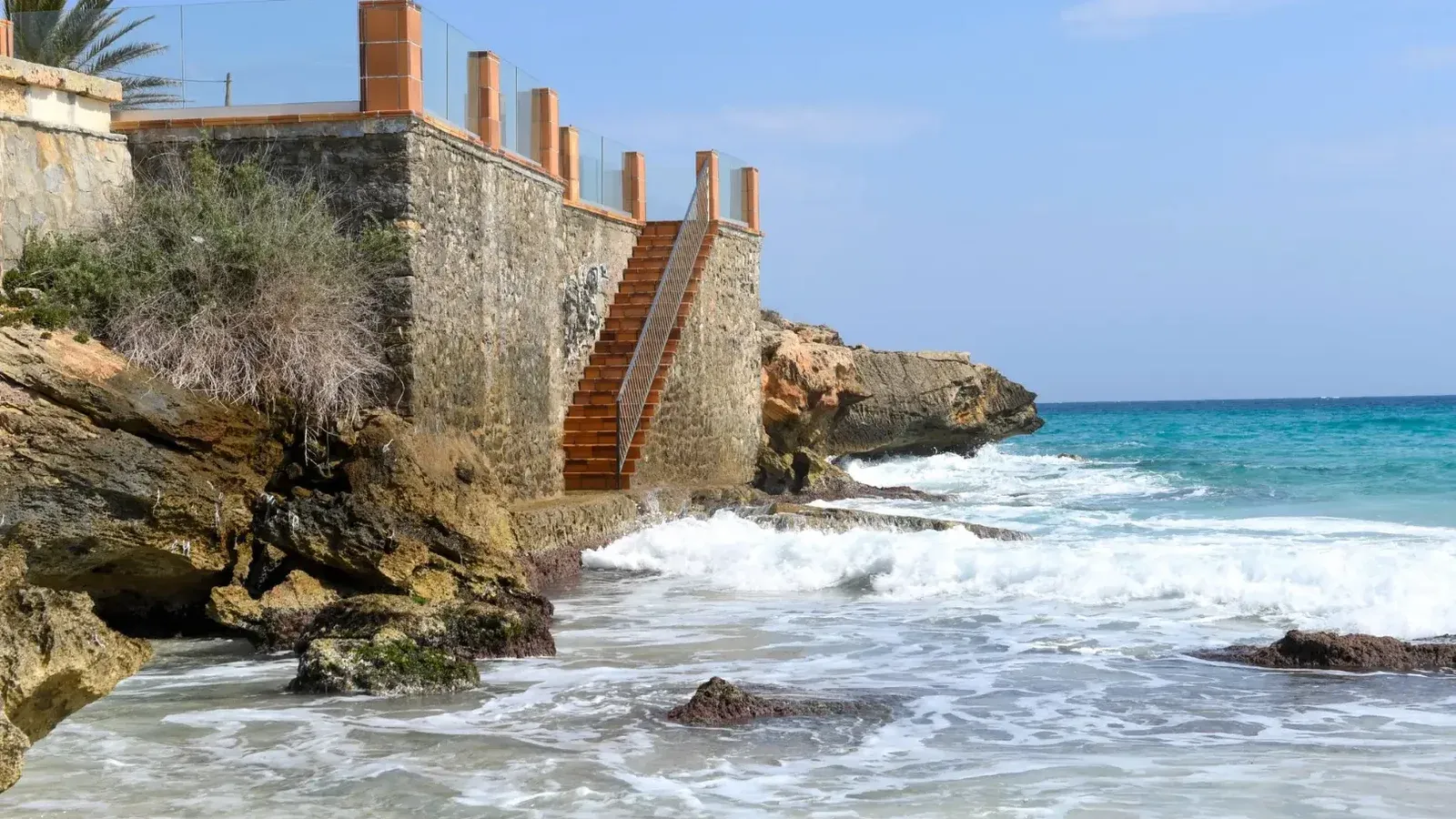 Escalera de piedra que conduce al Mediterráneo con una vista escénica costera en Mallorca, Islas Baleares, España.