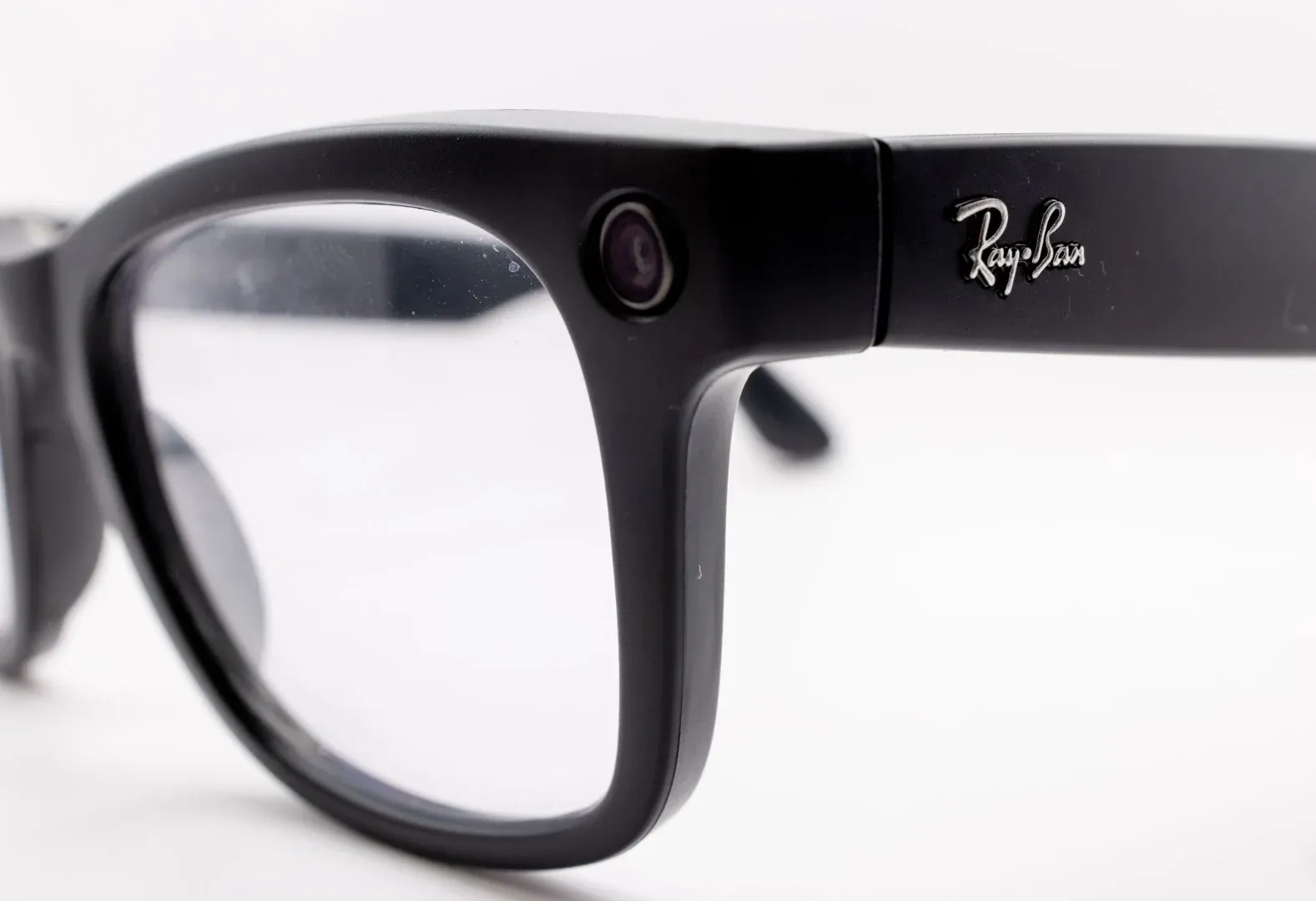 Detailed close-up shot of black smart glasses featuring a built-in camera, highlighting modern technology and design.