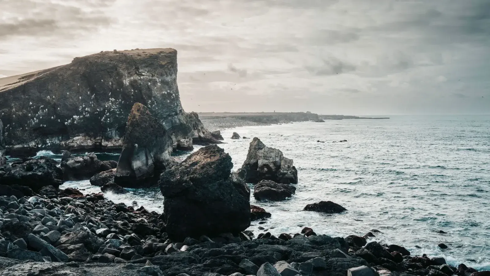 Impresionante vista de los escarpados acantilados costeros de Islandia y el vasto Océano Atlántico Norte durante un día nublado.