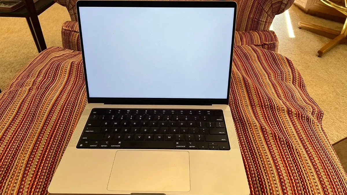 Un MacBook Pro plateado de 14 pulgadas 2021 con un fondo blanco liso.