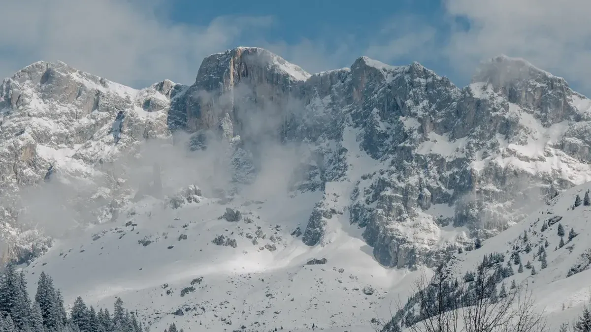 Impresionante vista de montañas cubiertas de nieve bajo un cielo despejado, perfecto para conceptos de viajes de invierno.