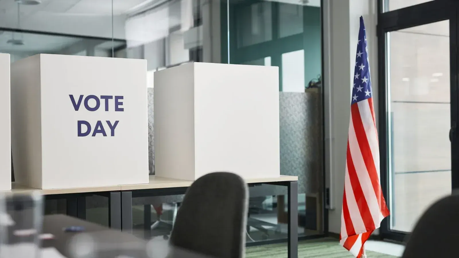 Voting booths with an American flag in an office, symbolizing Election Day.