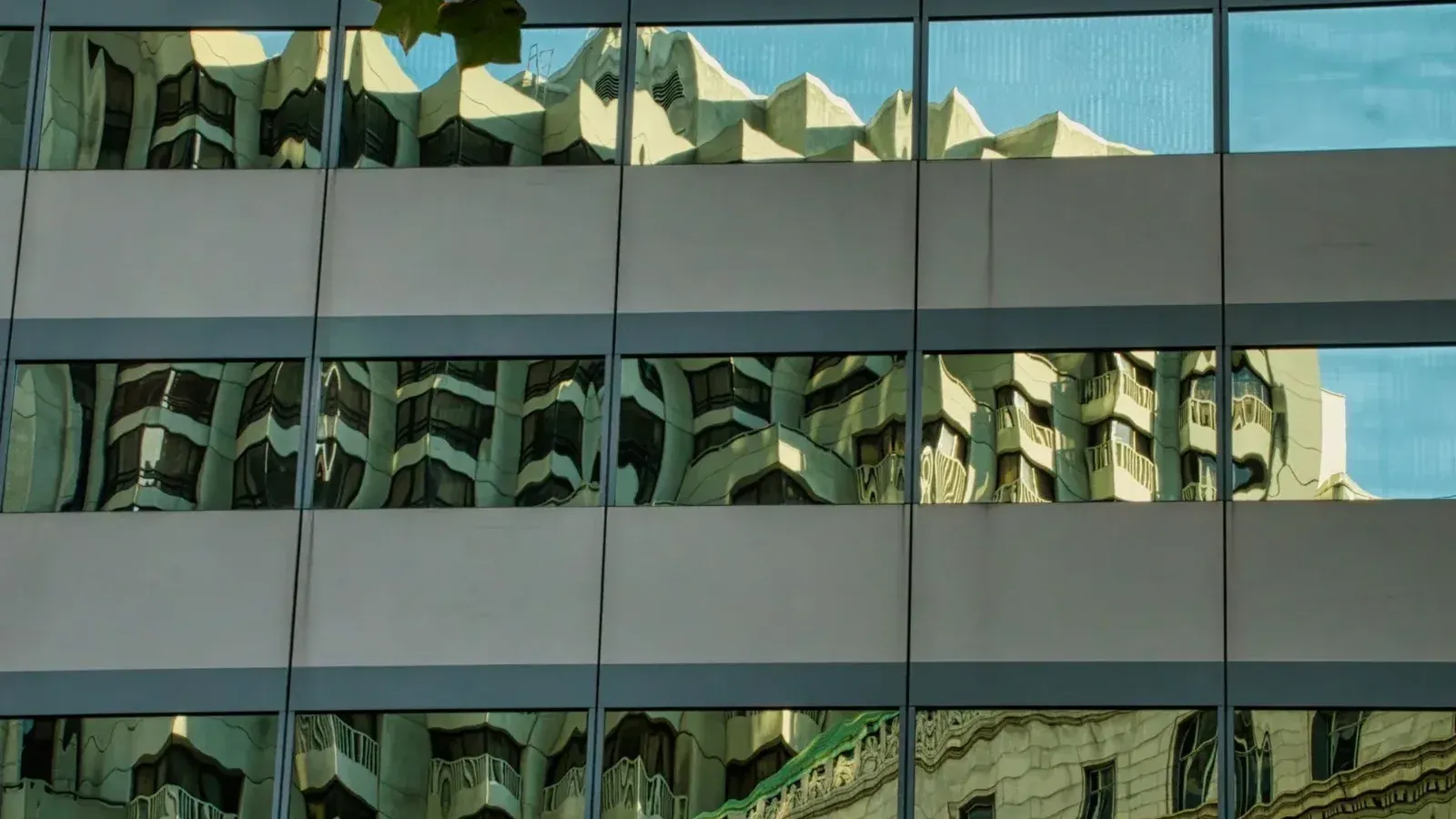 Reflexión del paisaje urbano sobre las ventanas de la fachada del edificio en San Francisco, CA.