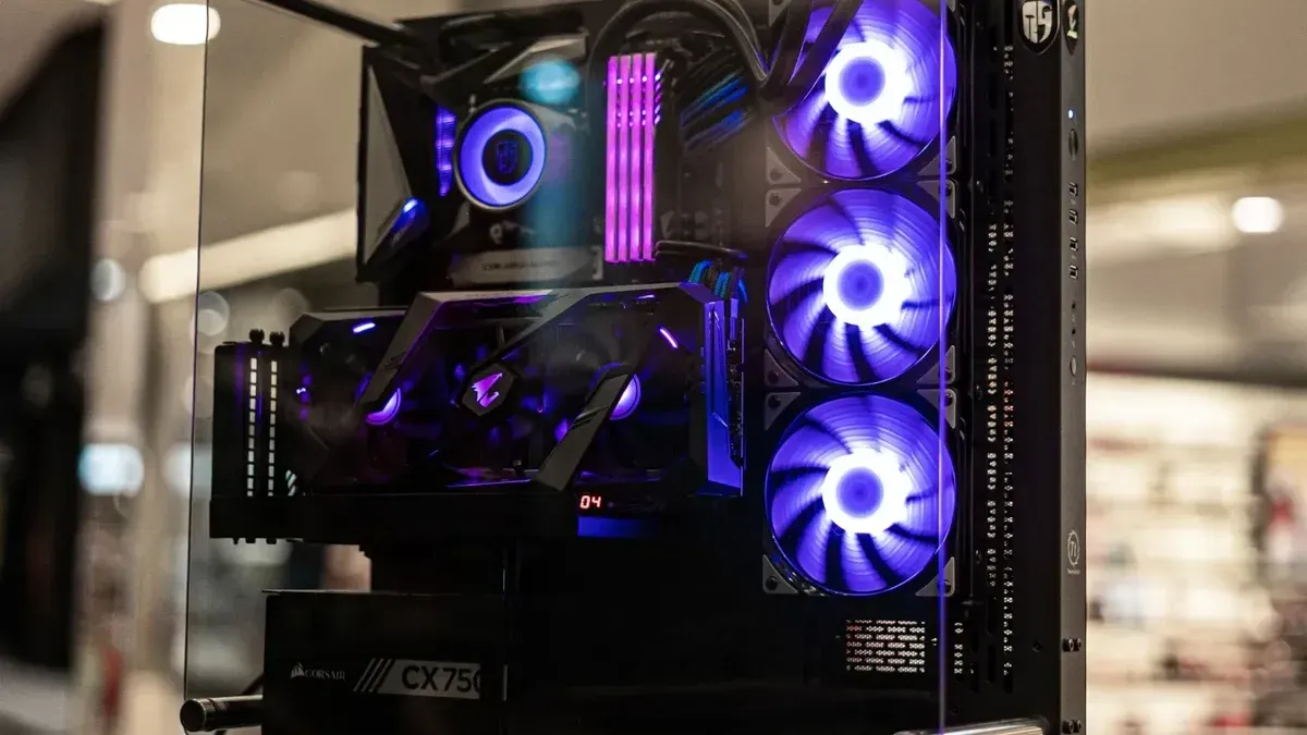 Modern gaming computer with vibrant LED fans and sleek glass design, showcasing high-performance components.