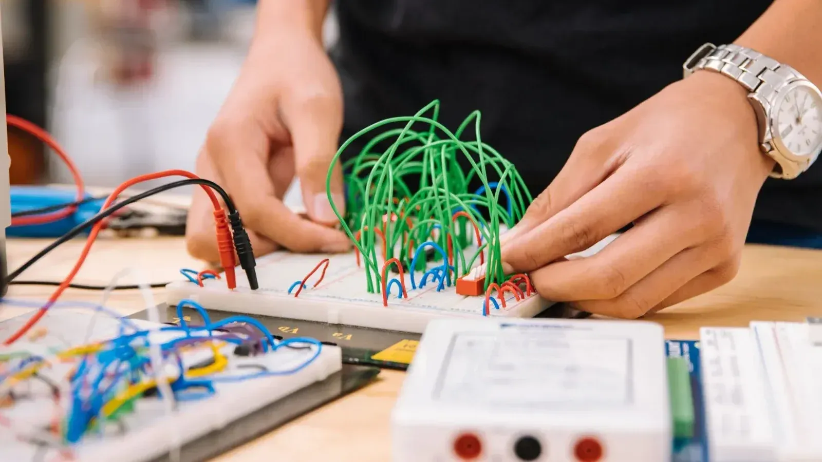 Manos de manipulación de cables en placas de prototipos para prototipos electrónicos.