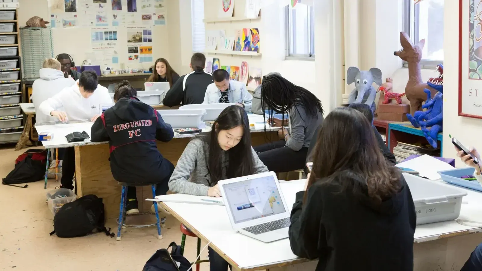 Un grupo de estudiantes diversos que estudian y colaboran en un salón de clases vibrante y creativo.