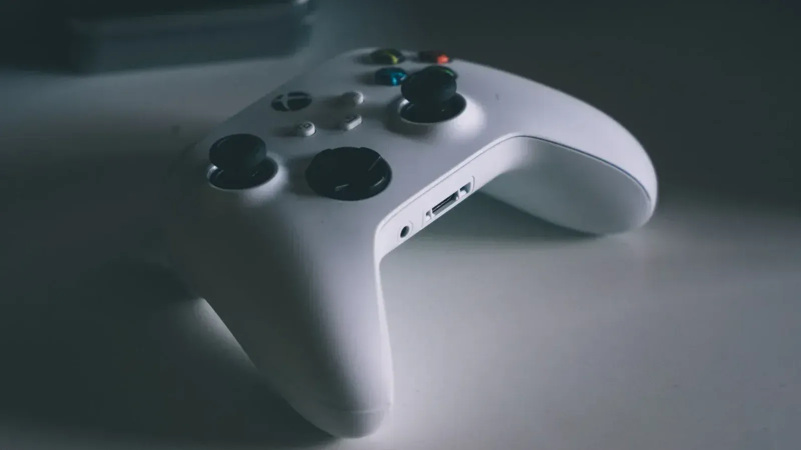 A detailed shot of a white gaming controller on a desk surface, perfect for tech and gaming themes.