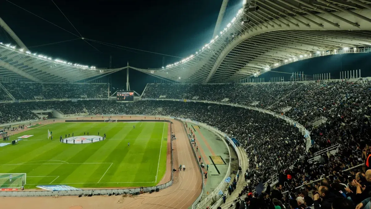 A crowded soccer stadium under bright lights at night, capturing the excitement of a live sports event.