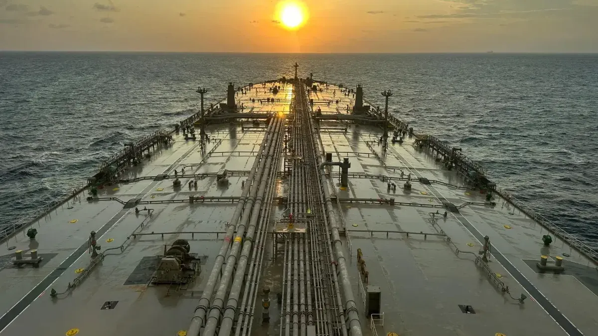 Un gran petrolero navegando en el océano con vista al atardecer.