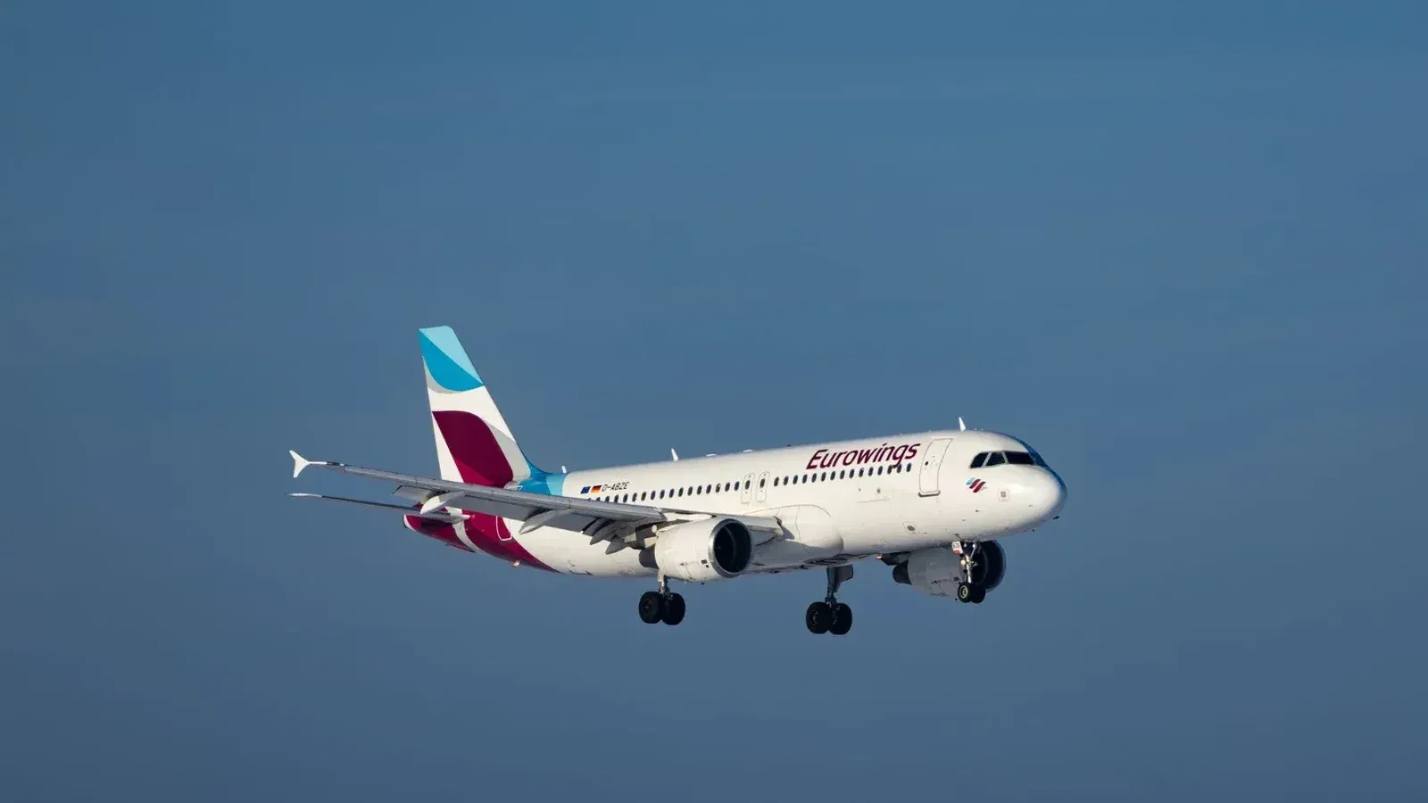 Un avión de Eurowings capturó a mitad de vuelo contra un cielo azul despejado, mostrando la dinámica de la aviación.