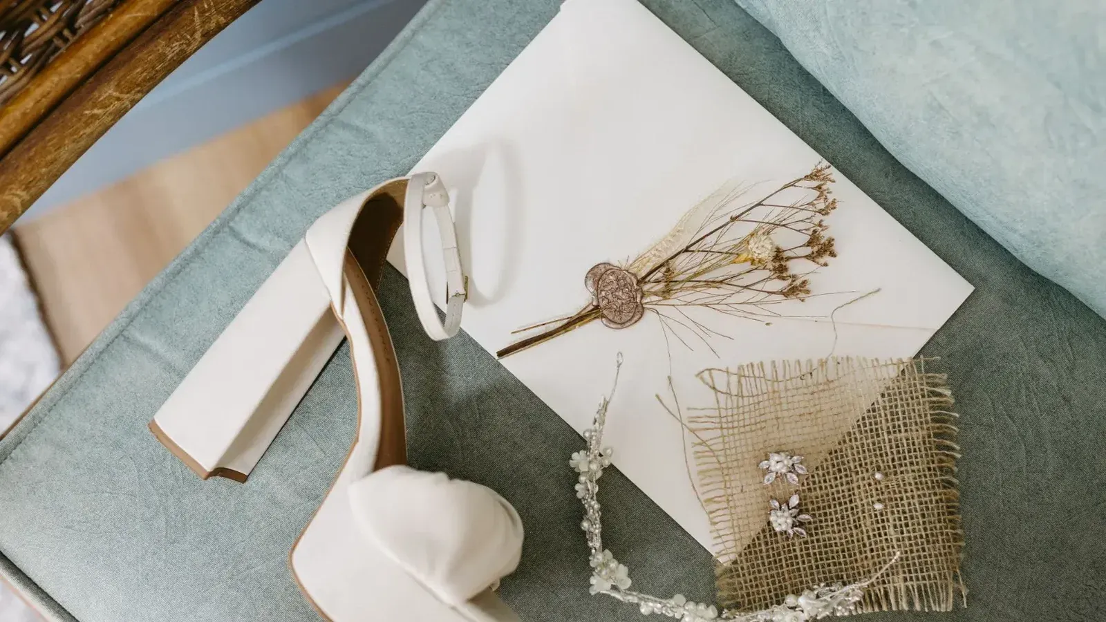 Tacón alto blanco y accesorios delicados en una silla vintage, perfecto para un tema nupcial.