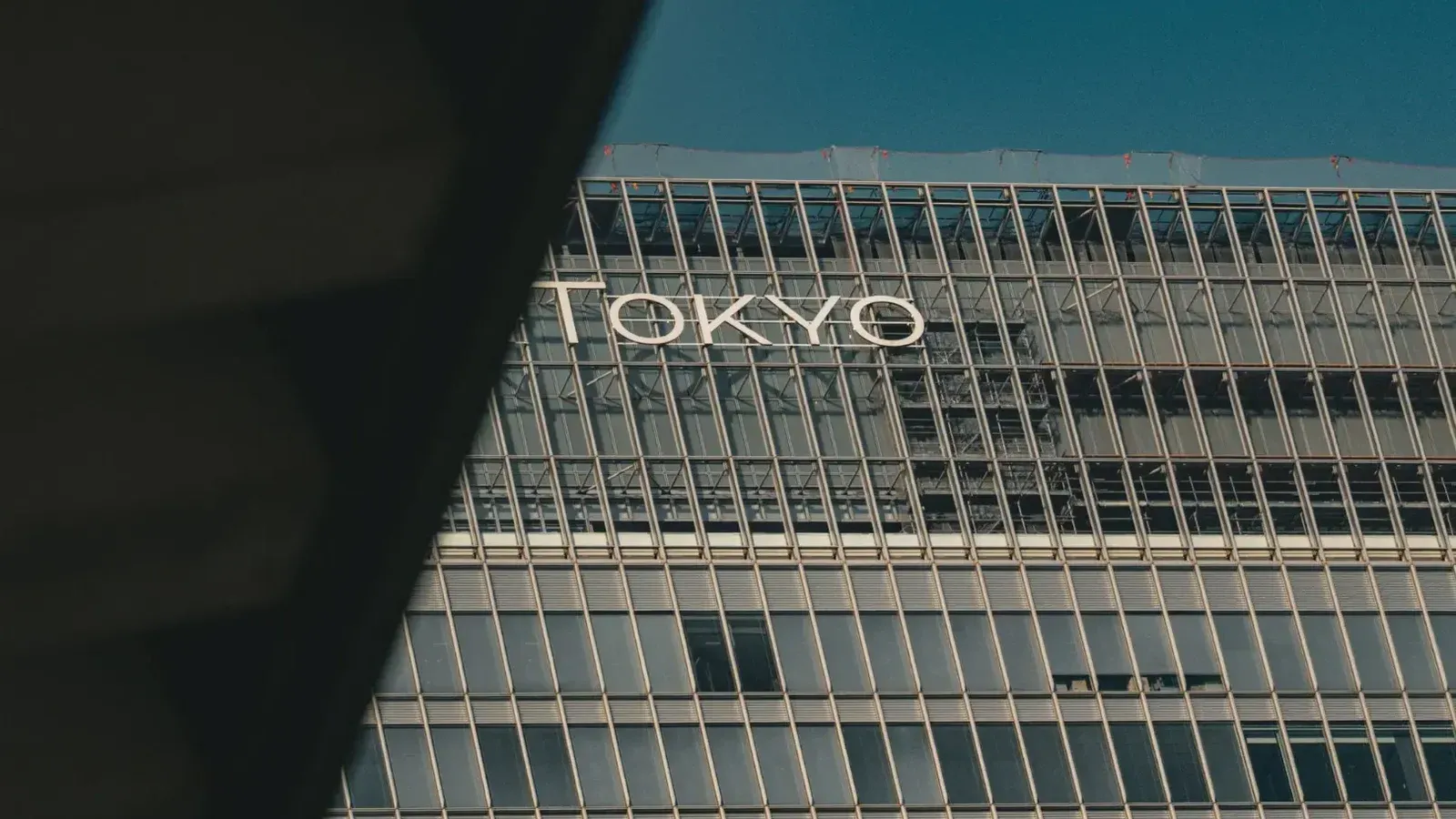 Una vista de un edificio moderno en Tokio con vidrio reflectante y arquitectura urbana.
