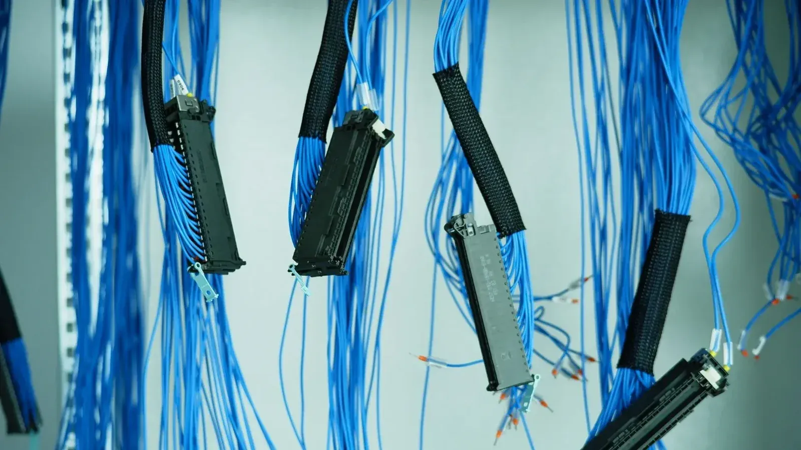 Close-up de cables Ethernet azules colgados en un centro de datos, destacando las conexiones tecnológicas.