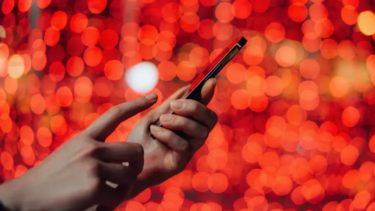 A hand holds a smartphone.