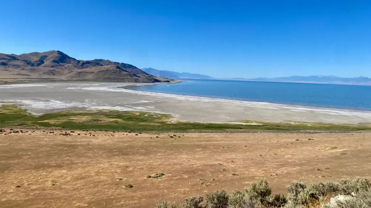 Paisaje sereno del Gran Lago Salado con montañas circundantes y cielos azules despejados.