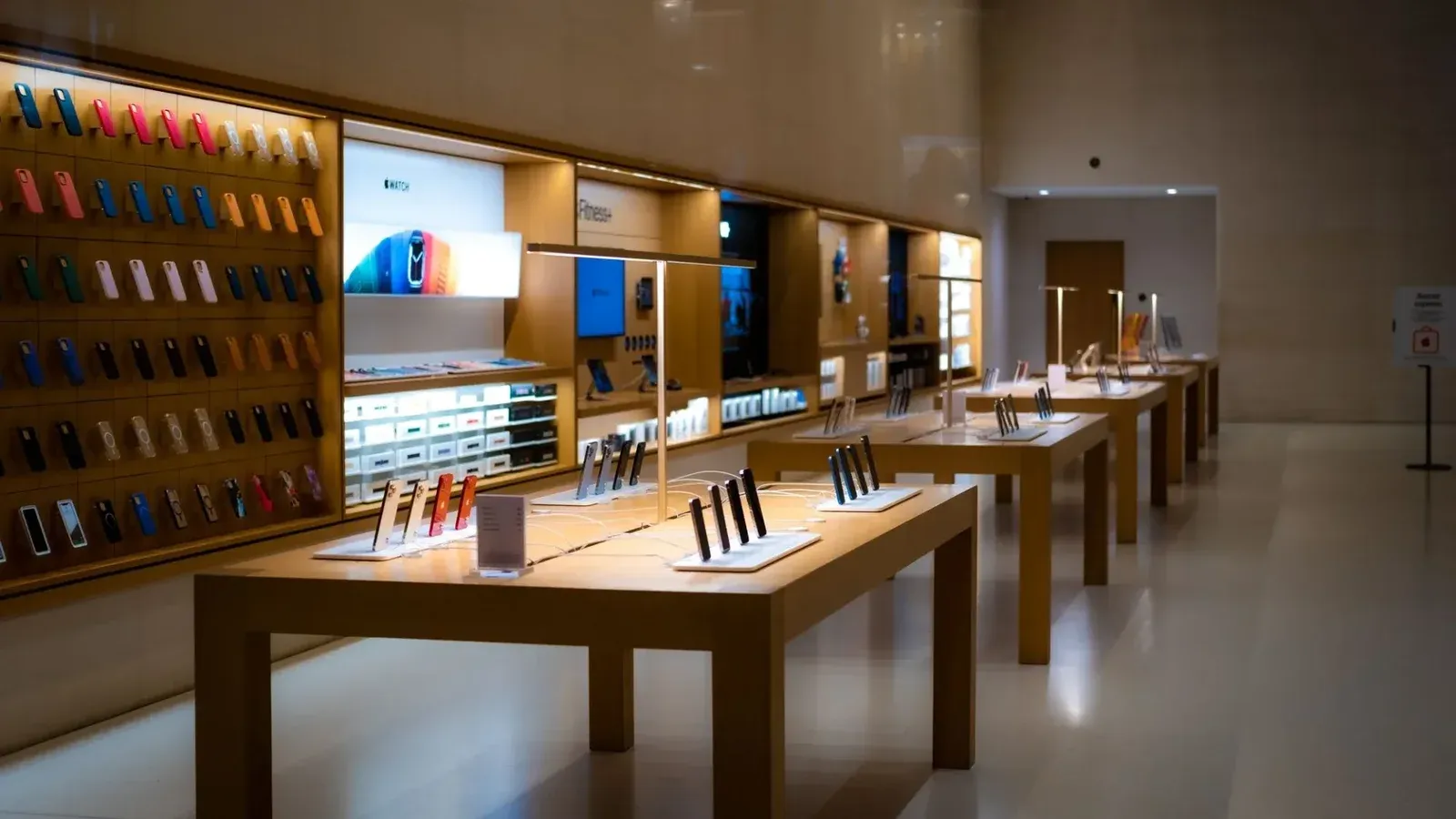 Elegante interior de una tienda de alta tecnología que muestra varios dispositivos móviles y accesorios.
