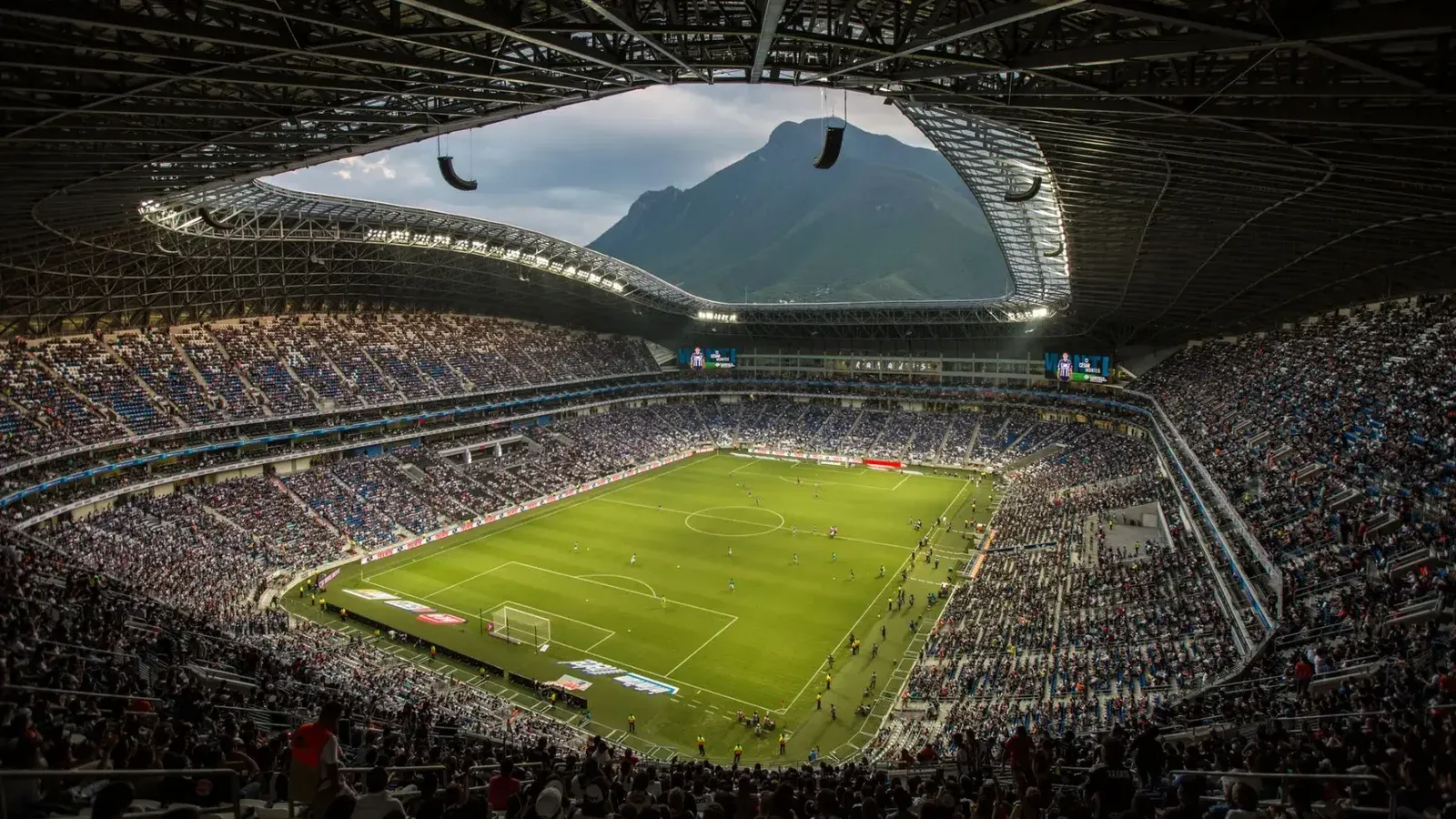 Un vibrante partido de fútbol en el Estadio BBVA con un telón de fondo de Cerro de la Silla, Monterrey.