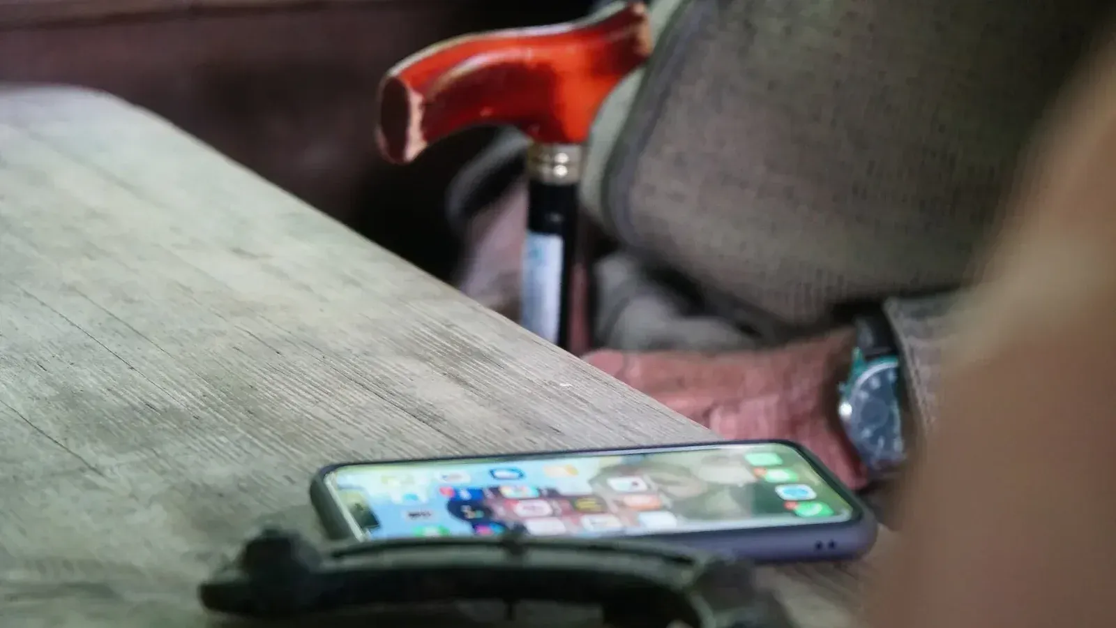 Ein Apple iPhone liegt auf einer Holz Tischkante.