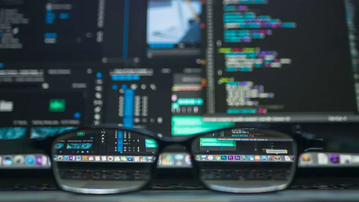 Gafas que reflejan el código de la computadora en un monitor, ideal para la tecnología y los temas de programación.