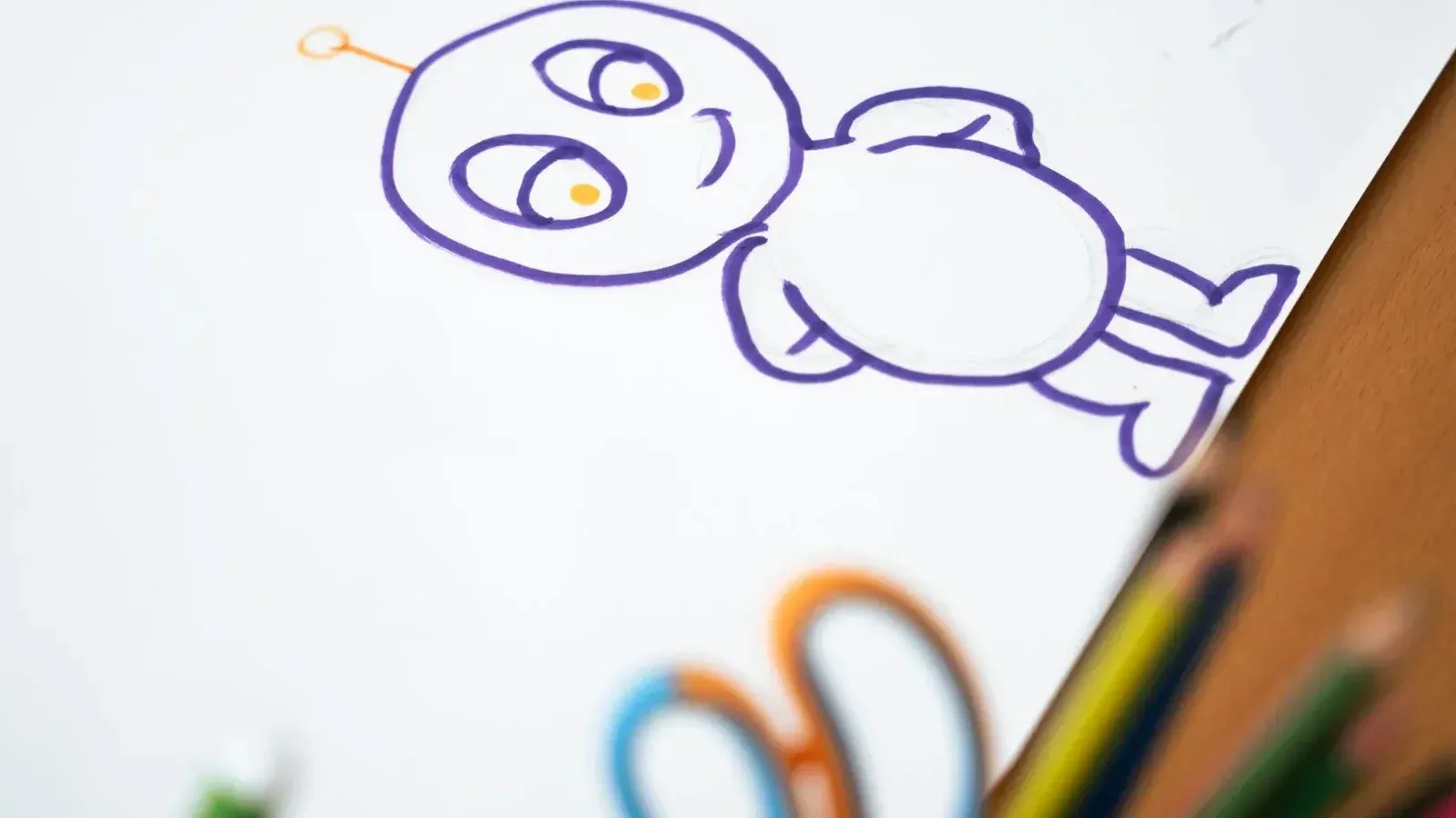 Boceto colorido del personaje de dibujos animados sobre papel con lápices de colores en el lado.